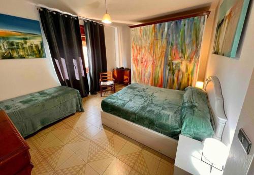 a bedroom with a green bed and a window at La casa dell’artista di Vittorio Vertone in Pietragalla