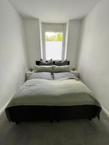uma cama grande num quarto com uma janela em Appartment Florida Nähe Düsseldorf, Messe, HBF, City, Netflix, WIFI, HELIOS Hospital em Krefeld
