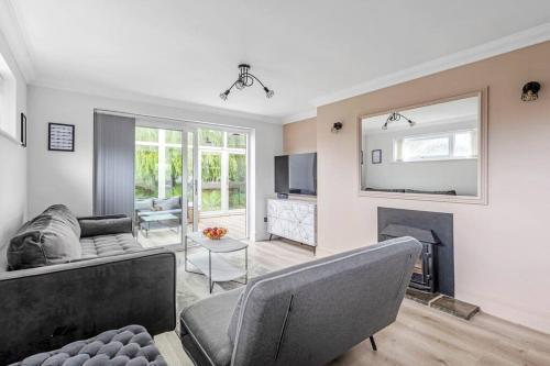 a living room with a couch and a fireplace at Waterside Cottage - Hot Tub, Mooring, Arcade, Bar in Neatishead