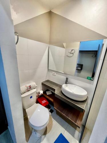 a bathroom with a white toilet and a sink at Hostal Lumar in Barranquilla