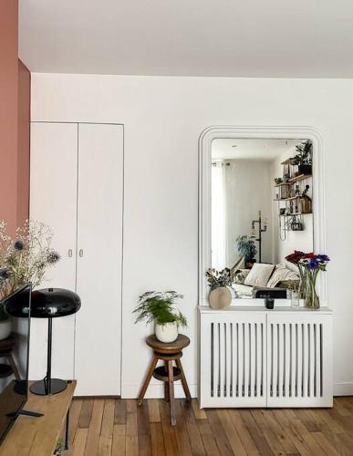 Habitación con espejo, mesa y taburete en Charmant appartement parisien, spacieux & lumineux en París