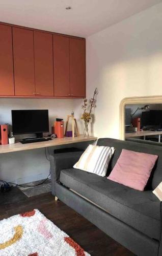 a living room with a couch and a desk at Charmant appartement parisien, spacieux & lumineux in Paris