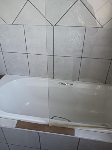 a shower with a glass door in a bathroom at Prison View Guesthouse 2 in Klerksdorp