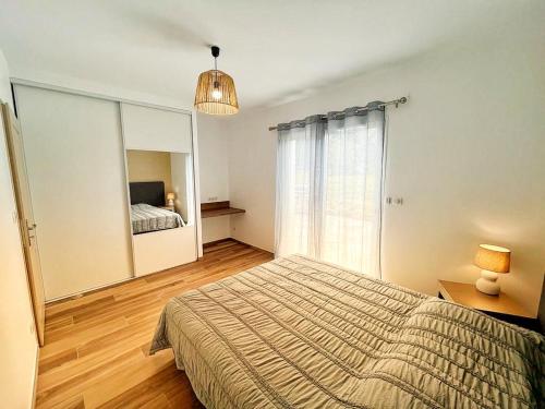1 dormitorio con cama y espejo grande en A PIAZZOLA en Petreto-Bicchisano
