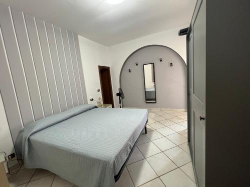 Schlafzimmer mit einem Bett und einem ovalen Spiegel in der Unterkunft Casa Isidora in Acquaviva