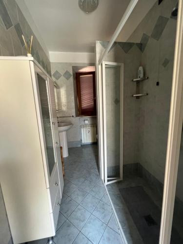a bathroom with a walk in shower and a refrigerator at Casa Isidora in Acquaviva