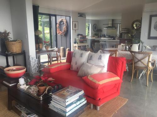 uma sala de estar com um sofá vermelho e uma mesa em 340 deg Alps & Sea em Christchurch