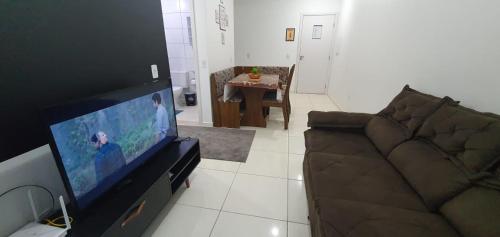 a living room with a couch and a flat screen tv at Condomínio Residencial Mar Azul in Imbituba