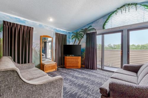 a living room with two chairs and a television at Atlantis Family Waterpark Hotel, an Ascend Collection Hotel in Wisconsin Dells