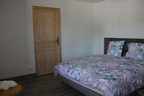 um quarto com uma cama e uma porta de madeira em Chambre d'hôtes Les Cinq Mésanges 