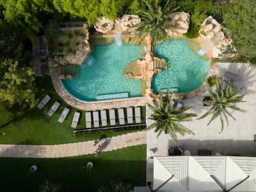 vista sul tetto di una piscina con palme di Hotel Capanna d'Oro a Lignano Sabbiadoro