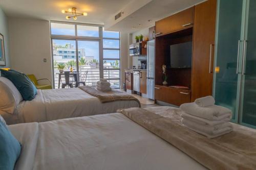 En eller flere senge i et værelse på Rooftop-Pool Suite on Ocean Dr C505