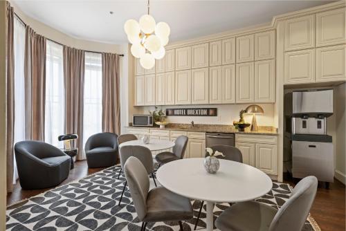 a living room with a table and chairs and a kitchen at Brexton Hotel in Baltimore