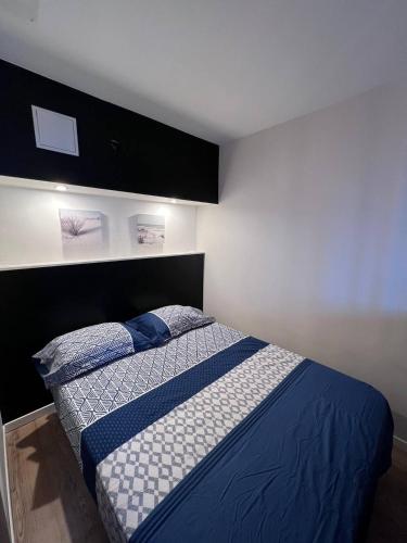 une chambre avec un lit avec des draps bleus et blancs dans l'établissement Location estival parfaite : Studio à 50 mètres de la plage, offrant une magnifique vue mer, à Fréjus