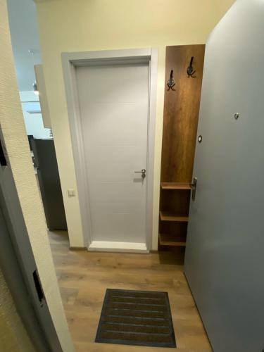a hallway with a white door and a rug at Tbilisi cozy apartment in Tbilisi City