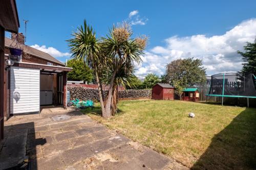 a backyard with a palm tree and a fence at Home in Peterborough in Peterborough