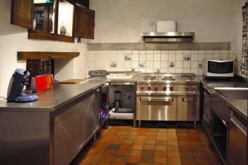 kuchnia z urządzeniami ze stali nierdzewnej w kuchni w obiekcie Le Chat Roi - Charneux w mieście Herve