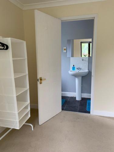 La salle de bains est pourvue d'un lavabo et d'un miroir. dans l'établissement Oasis, à Buckinghamshire
