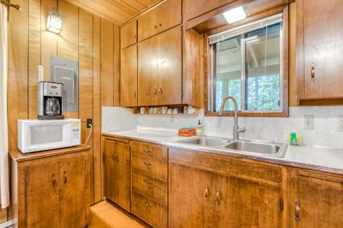 a kitchen with wooden cabinets and a sink and a microwave at Ski Haus in Government Camp