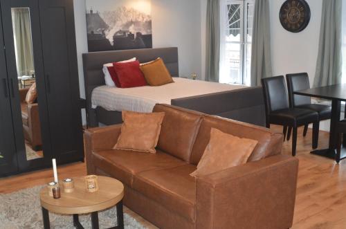 een woonkamer met een bank en een bed bij Hotel Buren in Buren