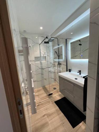 La salle de bains est pourvue d'une douche et d'un lavabo blanc. dans l'établissement Maison cosy Allauch, à Allauch