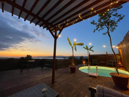 a patio with a hot tub and a deck with lights at Sapanca White Moon in Sapanca