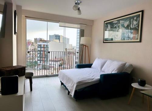 a bedroom with a bed and a large window at Encantador apartamento 2 habitaciones/ Cochera / Gimnasio in Lima