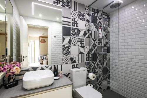 a bathroom with a toilet and a sink and a mirror at Porto Insight Apartments Campanhã in Porto