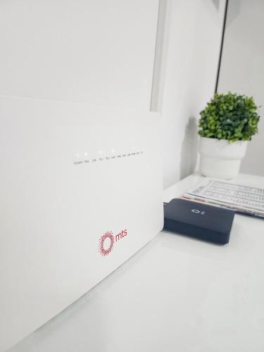 a white desk with a laptop and a box at OOTA Soko with Parking Garage in Kragujevac