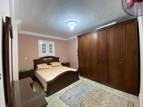 a bedroom with a bed and wooden cabinets at شقة للايجار اسكندرية in Alexandria
