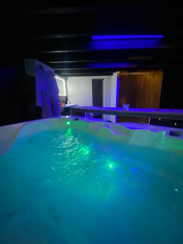 una piscina en una habitación con luces azules en Mieuxqualhotel jacuzzi privatif La retro, en Burdeos