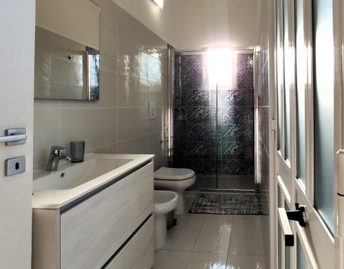 een witte badkamer met een toilet en een wastafel bij Villetta Gioia in Torre Lapillo