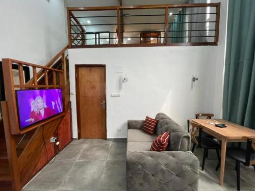 Wowo Loft Residence في برازافيل: غرفة معيشة مع أريكة وتلفزيون بشاشة مسطحة