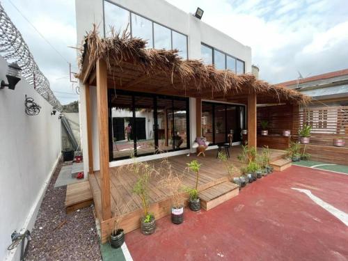 Wowo Loft Residence في برازافيل: منزل به سقف من القش ونباتات الفخار