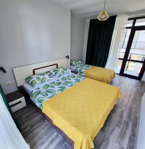 a bedroom with two beds and a window at Gina Apartments in Shekvetili