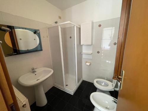 ein Badezimmer mit Waschbecken, Toilette und Dusche in der Unterkunft Casa Corbatto Family Apartment in Grado in Grado