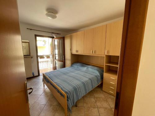 Schlafzimmer mit einem Bett, Schränken und einem Fenster in der Unterkunft Casa Corbatto Family Apartment in Grado in Grado