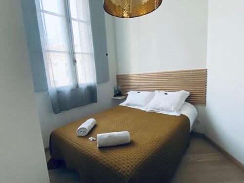 a bedroom with a bed with two towels on it at Mieuxqualhotel jacuzzi privatif Le carré in Bordeaux