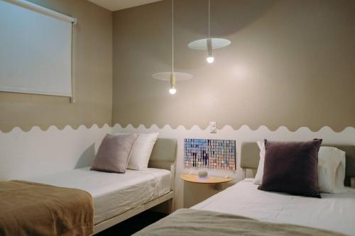 sypialnia z 2 łóżkami, stołem i oknem w obiekcie ¡Sivar Sound! Music Design! w mieście San Salvador