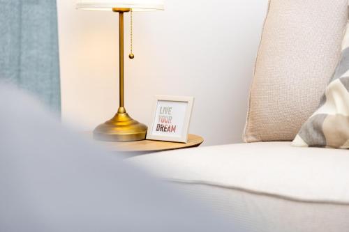a lamp on a night stand next to a bed at 10 min walk to Schonbrunn l Deluxe Suite in Vienna