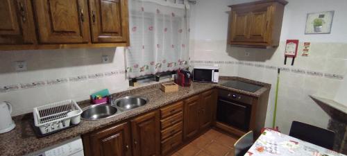 a small kitchen with wooden cabinets and a sink at Casa Viela in Viseu