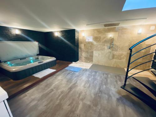 La salle de bains est pourvue d'une baignoire, d'un lavabo et d'une douche. dans l'établissement Mieuxqualhotel jacuzzi privatif Le carré, à Bordeaux