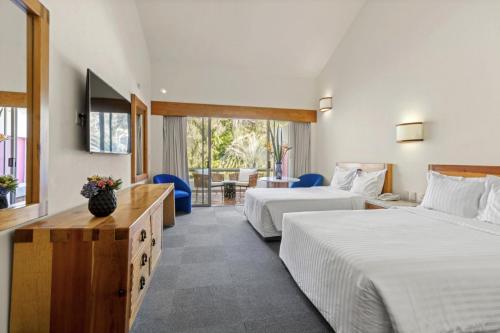 Cette chambre comprend deux lits et une télévision. dans l'établissement Hotel Rancho San Diego Grand Spa Resort, à Ixtapan de la Sal