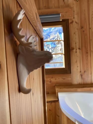 une statue d'une tête de cerf sur le mur d'une petite maison dans l'établissement BEAU CHALET DE MONTAGNE SERRE CHEVALIER AU PIED DES PISTES PLEIN SUD, à La Salle Les Alpes