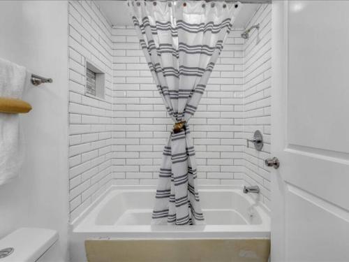 eine Badewanne mit Duschvorhang im Bad in der Unterkunft Quaint 3/2.5 home in Fort Dupont in Washington