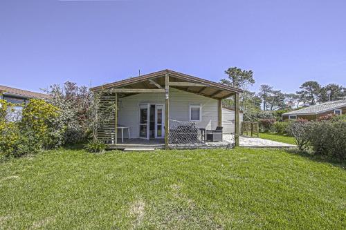 une petite maison avec un kiosque dans une cour dans l'établissement La Coquille PRL 37, à Grandcamp-Maisy