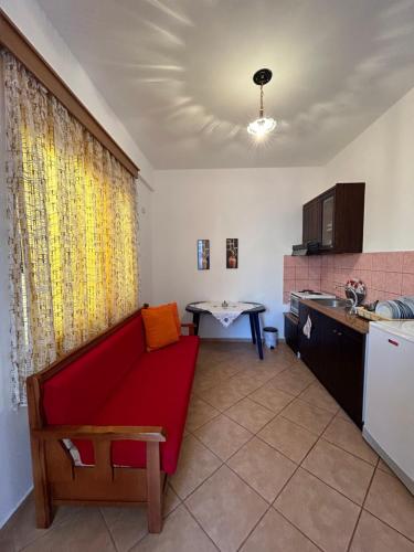 sala de estar con sofá rojo en la cocina en Shehu's Apartments, en Sarandë