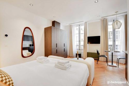 une chambre avec un lit blanc et un miroir dans l'établissement Modern Studio - 2P - Opéra Garnier, à Paris