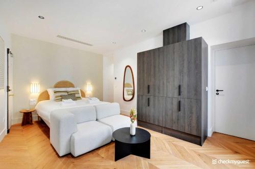 - une chambre blanche avec un lit blanc et une table dans l'établissement Modern Studio - 2P - Opéra Garnier, à Paris