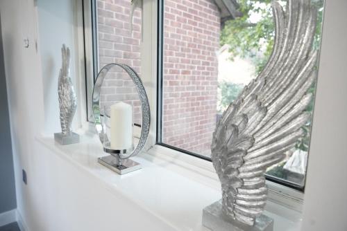 a window sill with a mirror and a candle at Ricoh Arena/Newly Refurbished Semi-Detached House in Coventry